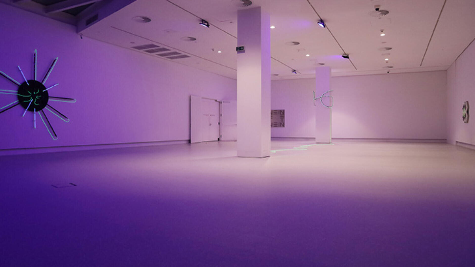 Eine geräumige, moderne Kunstgalerie mit violetter Beleuchtung, weißen Wänden und minimalistischen Kunstwerken mit leuchtenden, abstrakten Formen an den Wänden. Die Galerie ist leer und hat einen sauberen, glatten Boden.