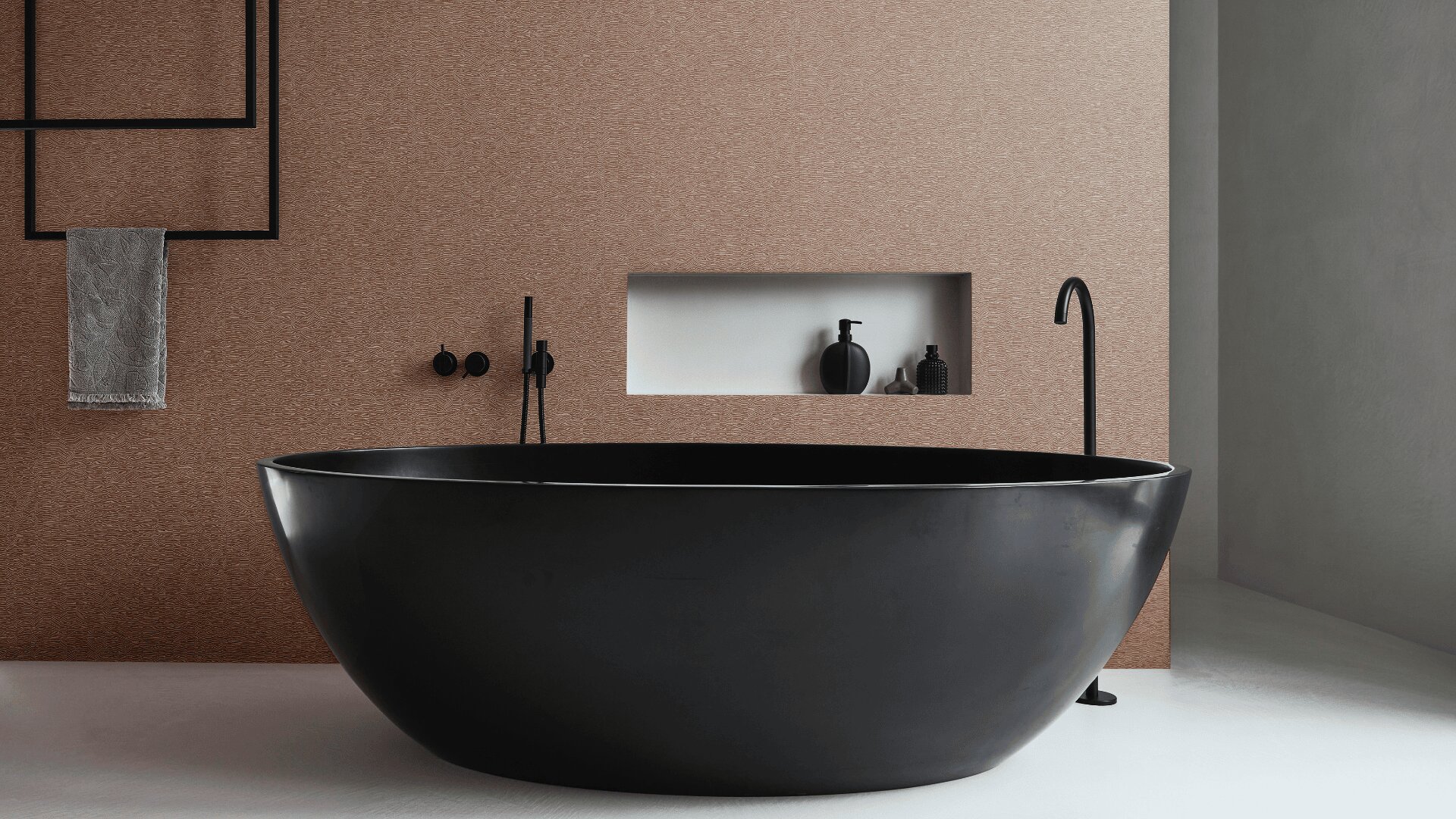 Ein modernes Badezimmer mit einer großen, mattschwarzen ovalen Badewanne, einer braun strukturierten Wand, minimalistischen schwarzen Armaturen, einem eingebauten Wandregal mit Toilettenartikeln und einem Handtuch, das an einem schwarzen Rahmen hängt. Der Boden ist glatt und hell.