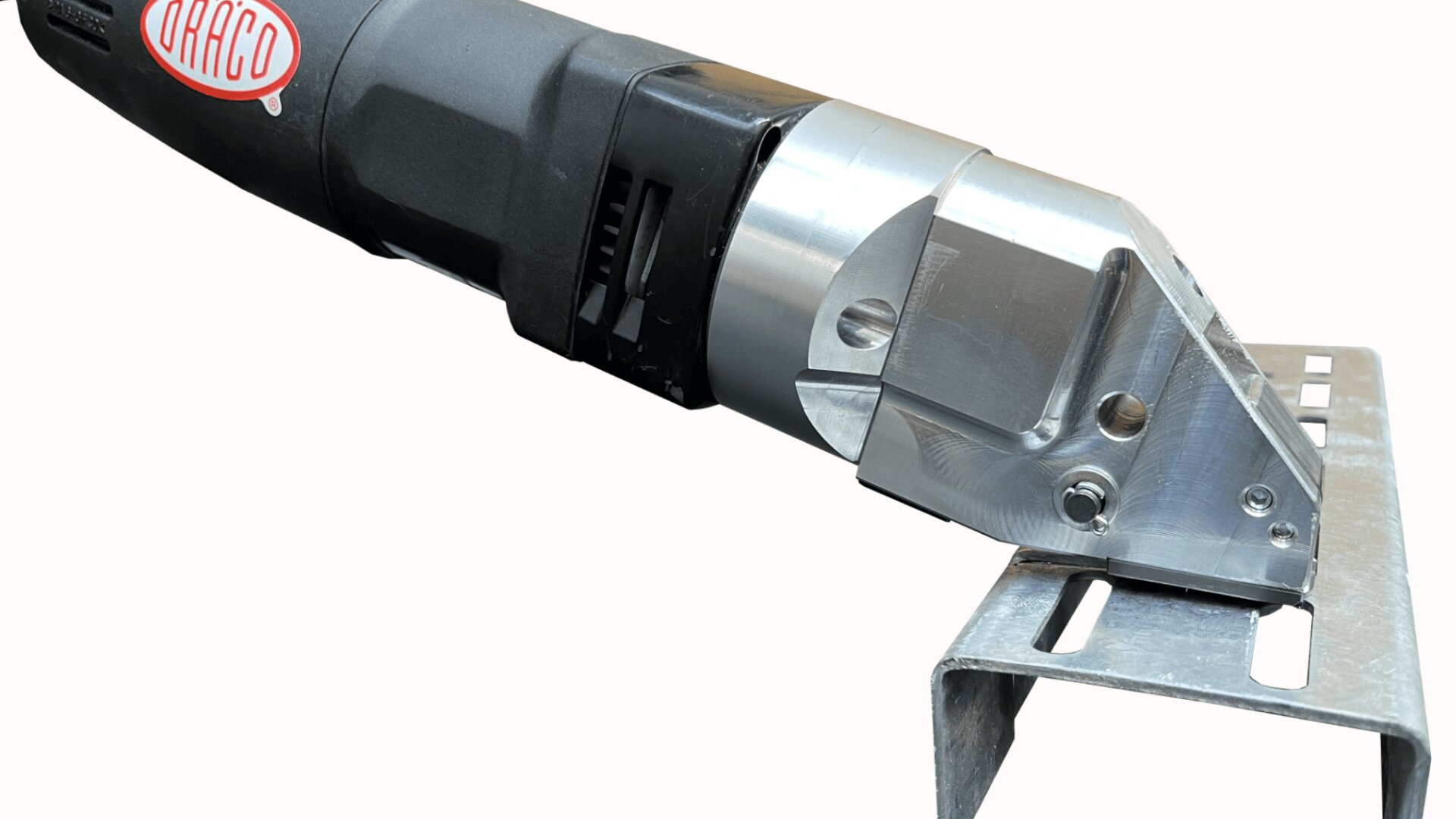 Eine Nahaufnahme eines Metallschneidwerkzeugs mit schwarzem Griff und silberner Klinge, das ein Stück eines U-förmigen Metallkanals durchschneidet.