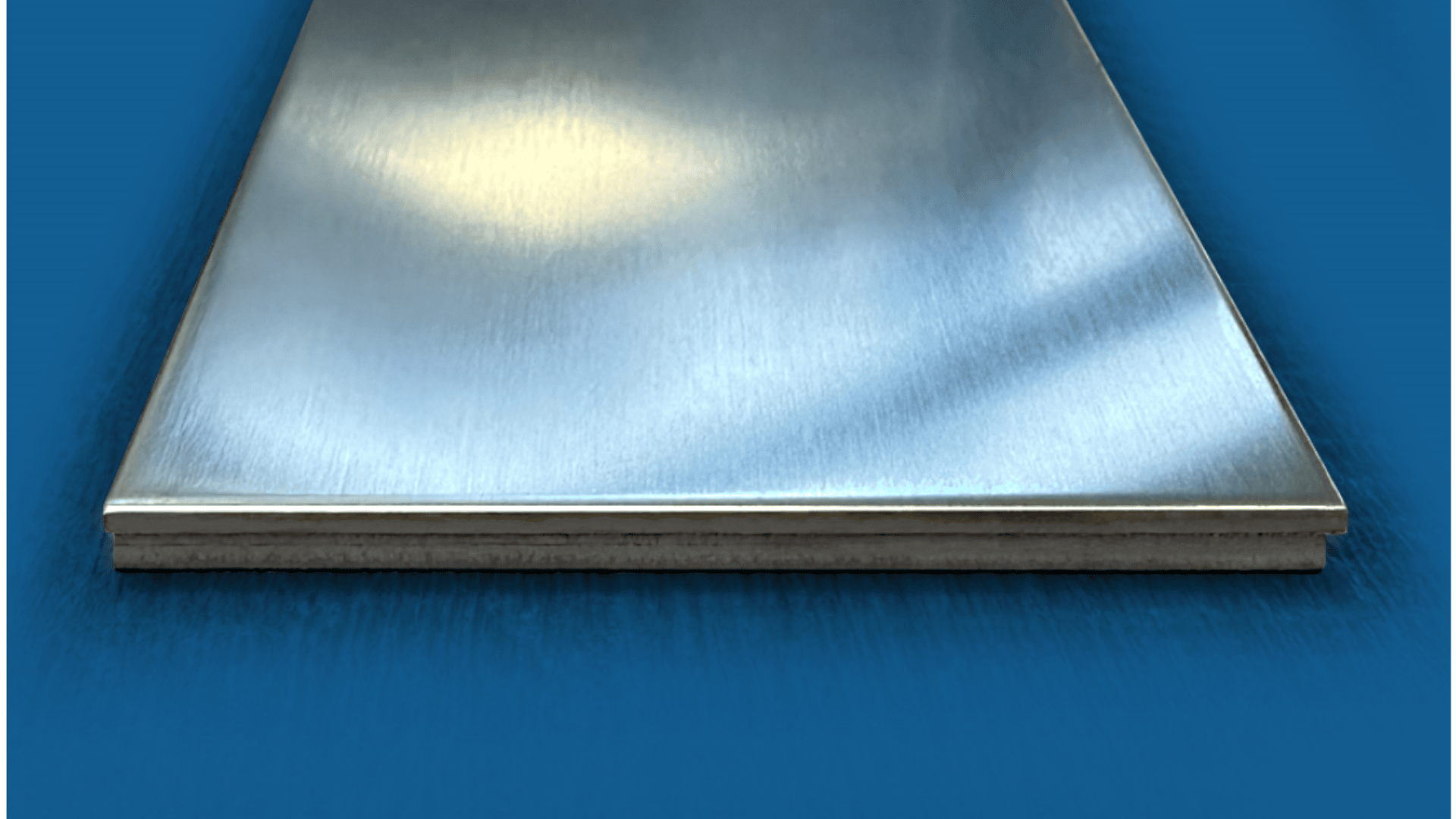Eine Nahaufnahme eines glatten, polierten Metallblechs mit reflektierender Oberfläche auf blauem Hintergrund.