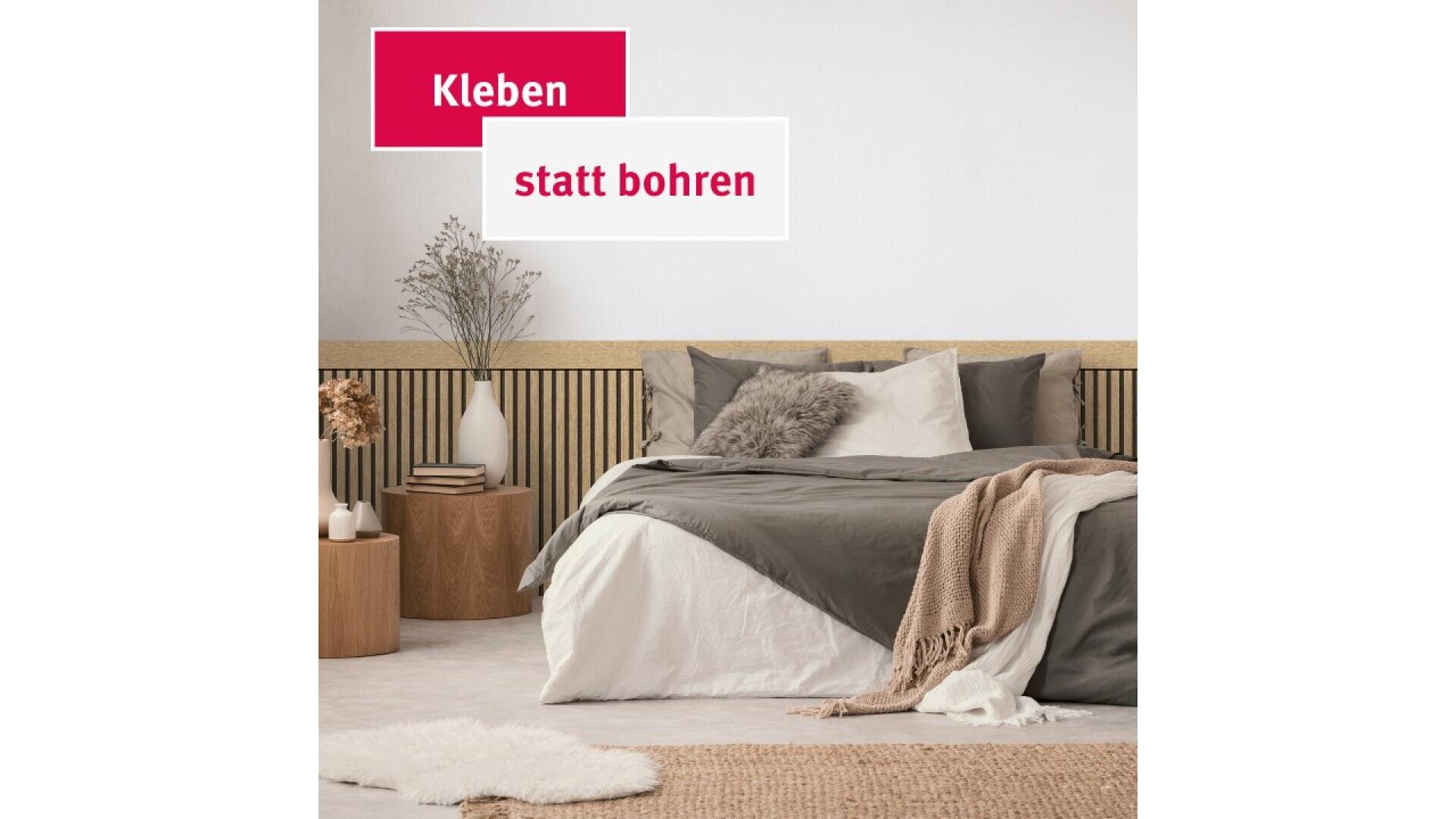 A modern bedroom with a neatly made bed in neutral tones, a beige throw, wooden side tables, vases with dried plants, and the German text Kleben statt bohren in bold blocks on the wall.