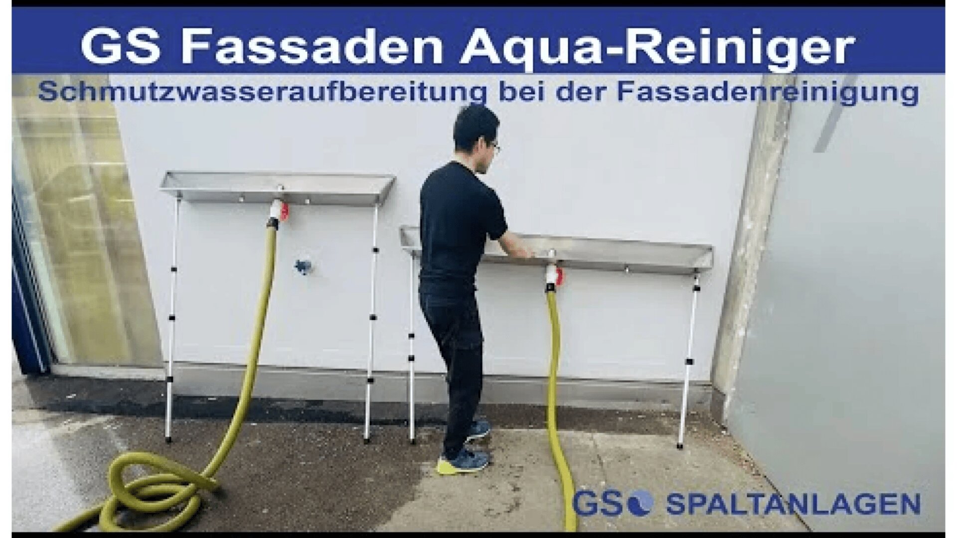 A man uses a hose attached to a metal cleaning station labeled GS Fassaden Aqua-Reiniger on a white wall, with text promoting wastewater treatment for facade cleaning.