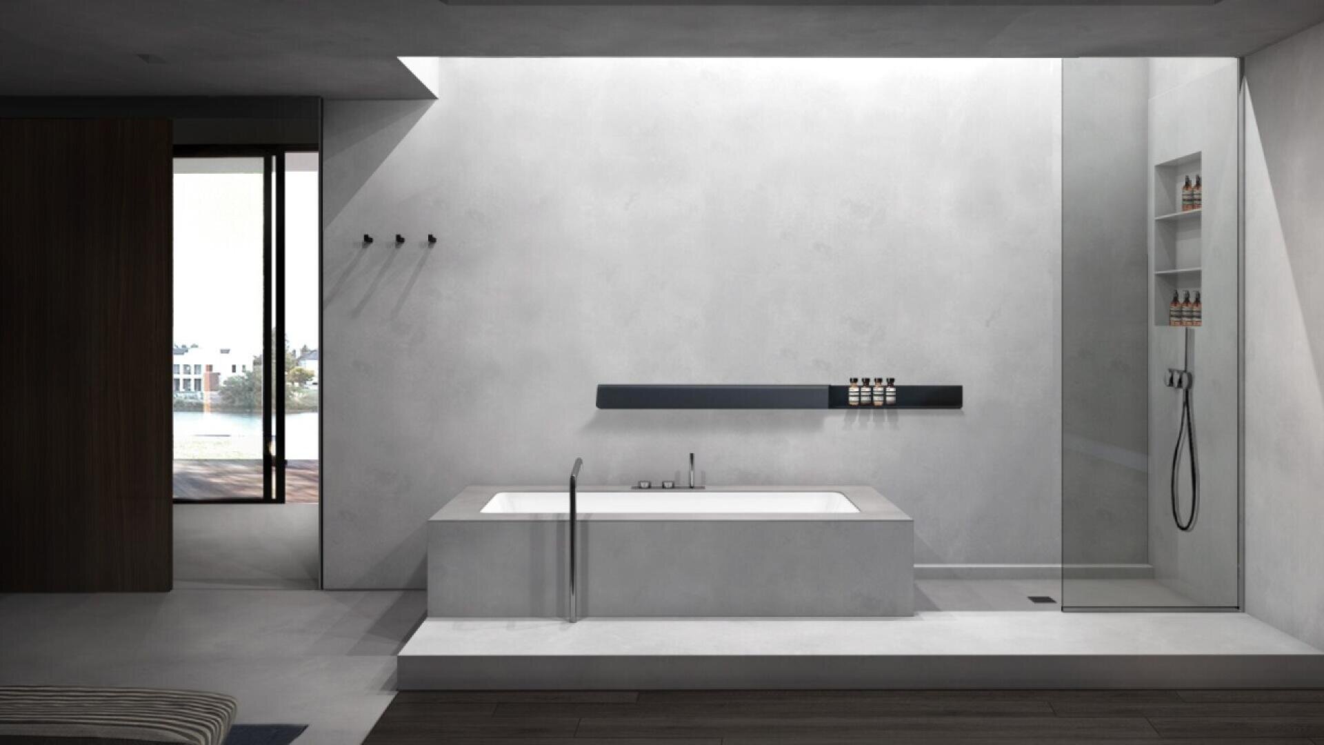 A modern, minimalist bathroom with a sunken bathtub, wall-mounted shelf, and a glass-enclosed shower. Light gray walls and clean lines create an open, airy feel. A window offers a view of buildings and water outside.