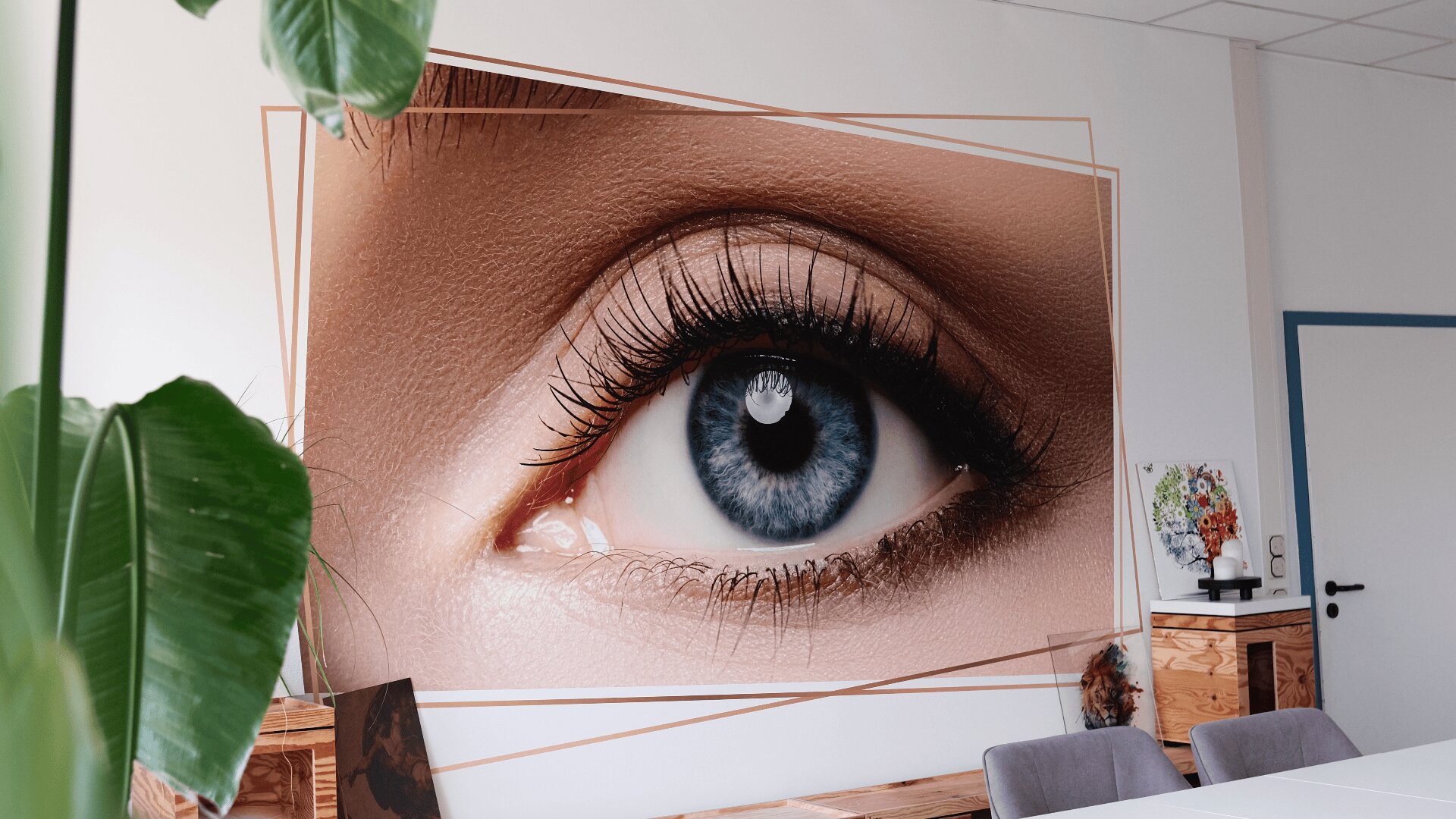 Ein großes Poster mit der Nahaufnahme eines blauen Auges hängt in einem modernen Büro mit weißen Wänden, Pflanzen, einem Holzschrank und einer Kamera auf einem Stativ im Hintergrund.