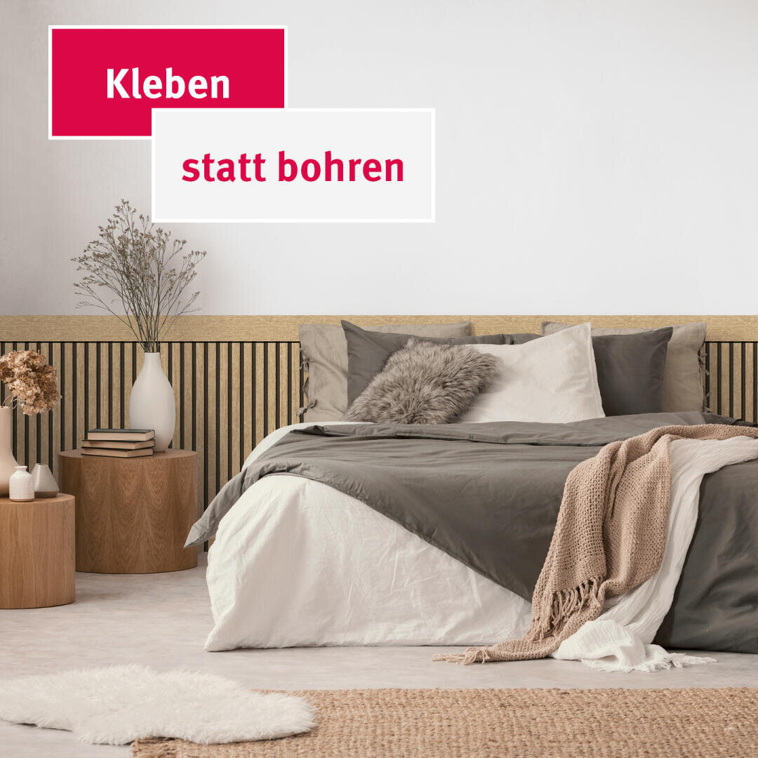 Ein modernes Schlafzimmer mit einem ordentlich gemachten Bett mit grauer, weißer und beiger Bettwäsche, kuscheligen Kissen, einer Strickdecke und hölzernen Beistelltischen mit dekorativen Vasen. Der Text auf Deutsch lautet: „Kleben statt bohren“.