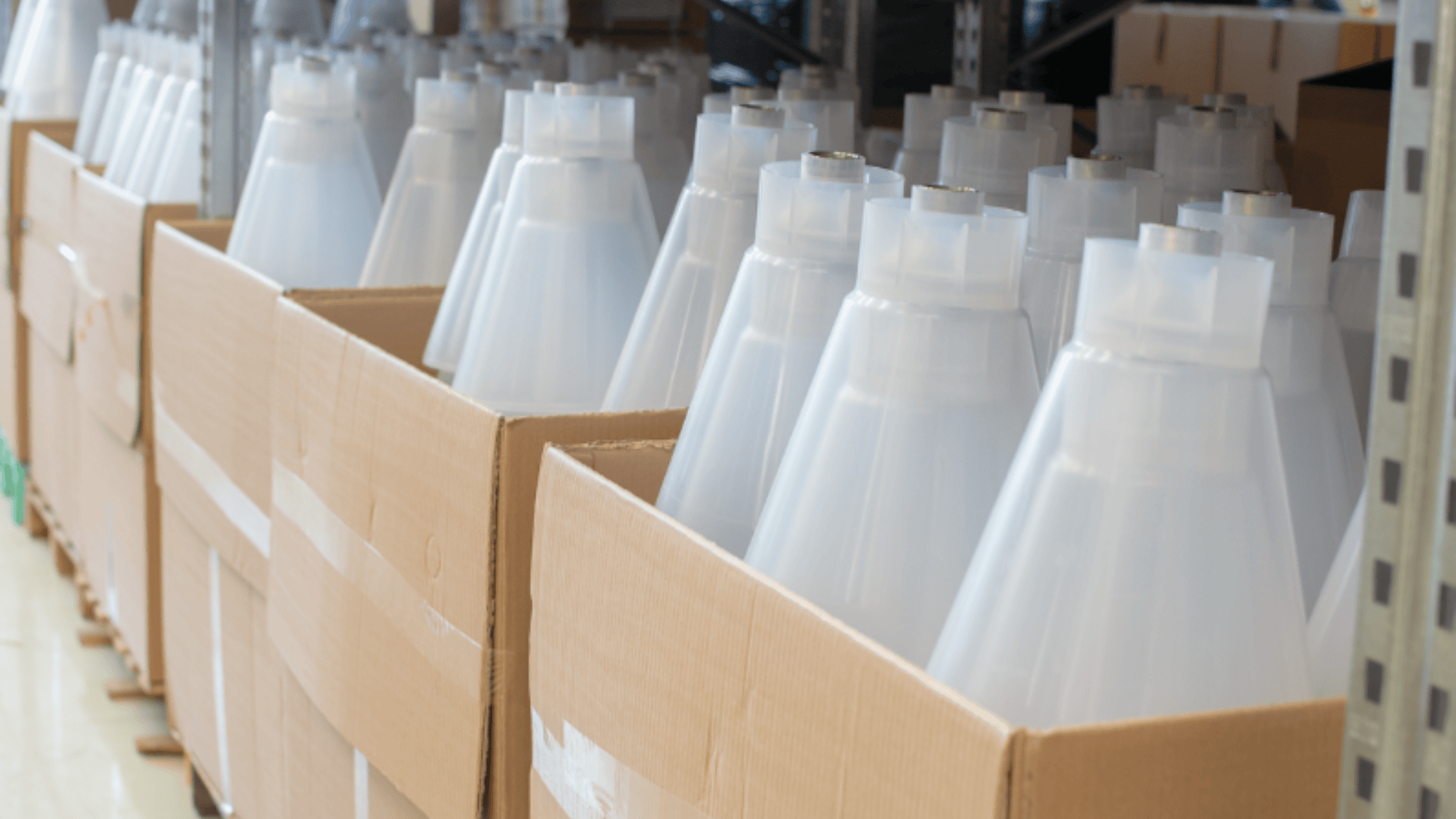 Reihen großer, durchsichtiger Plastikkegel sind ordentlich in Kartons verpackt, die auf industriellen Metallregalen in einem Lager oder einer Lagereinrichtung stehen.