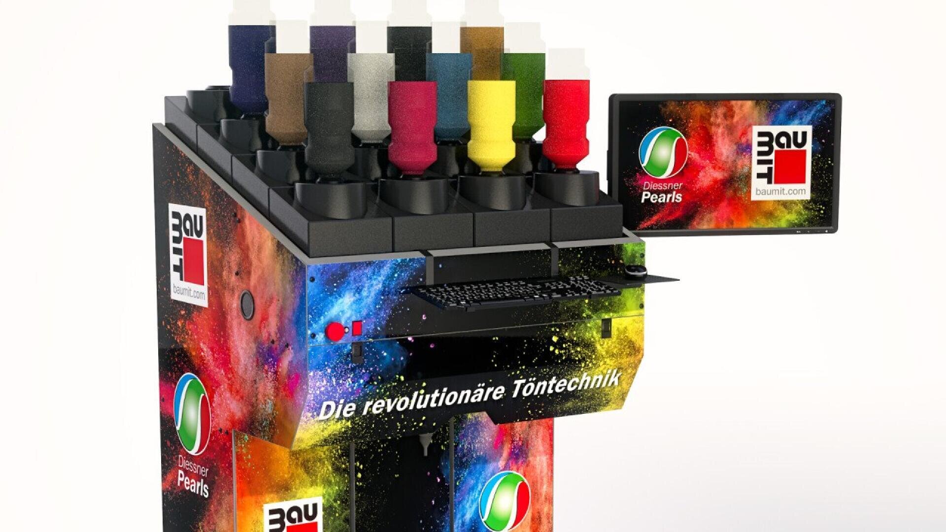 A colorful paint mixing machine with multiple paint containers on top, a keyboard, and a monitor displaying the Baumit logo. The text Die revolutionäre Töntechnik is written on the front.