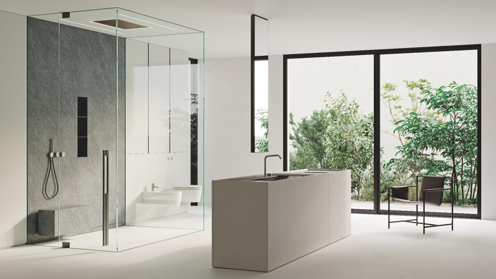 Minimalist bathroom with a glass shower enclosure, gray accent wall, modern sink island, and floor-to-ceiling windows revealing a garden with green plants. A black chair sits near the windows.