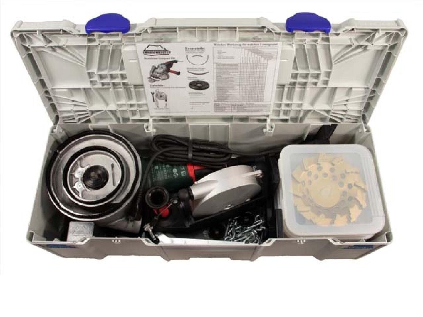 Offener grauer Werkzeugkasten mit einer Kreissäge, Sägeblättern, einem Netzkabel, verschiedenen Metallteilen und einer durchsichtigen Kunststoffbox mit zusätzlichen Sägeblättern; im Deckel ist eine Anleitung angebracht.