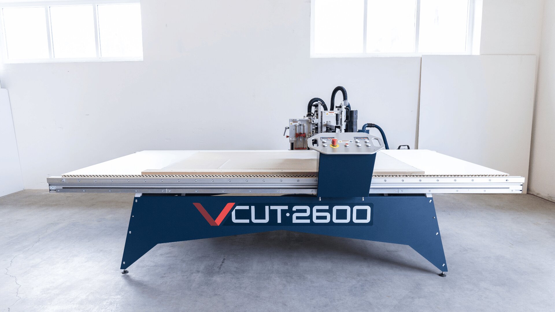 Eine große industrielle CNC-Maschine mit der Bezeichnung VCUT:2600 steht in einem hellen, geräumigen Raum mit weißen Wänden und Fenstern auf einem Betonboden.