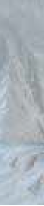 A close-up of a light gray, crumpled fabric with soft folds and subtle shadows.